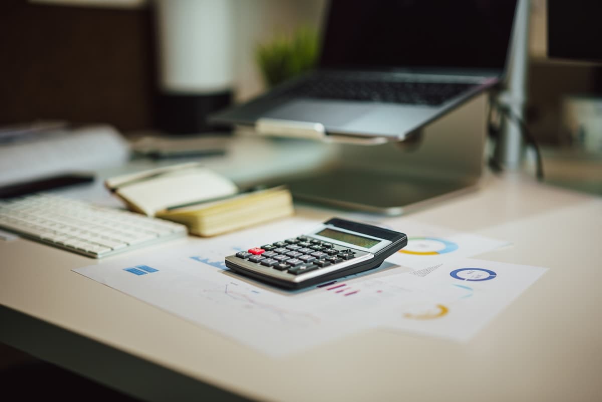 A desk with a laptop, calculator and tax paperwork